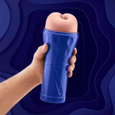 Hand holding a blue ergonomic stroker with a soft, flesh-toned textured sleeve against a dark blue abstract background.