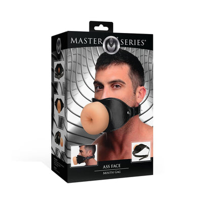 Packaging of Master Series Ass Face Mouth Gag featuring a man wearing a black vegan leather gag with a realistic TPE design.