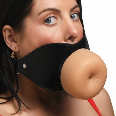 Close-up of a woman wearing a black vegan leather mouth gag with a realistic, flesh-toned TPE front piece.