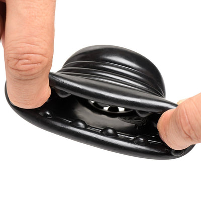 Close-up of black stretchy ball stretcher with textured nubs inside, held open by two fingers to show flexibility and detail.