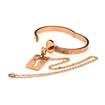 Rose-gold locking bracelet with heart-shaped clasp and matching key necklace on chain, elegant tungsten steel jewelry set.