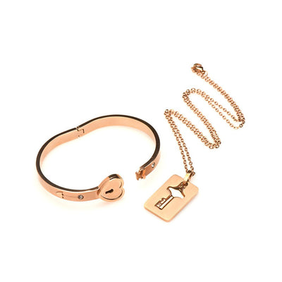 Rose-gold locking bracelet with heart-shaped clasp and matching key necklace on a chain, elegant tungsten steel jewelry set.