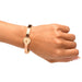Rose-gold locking bracelet with heart-shaped clasp and small crystals worn on wrist against white background.