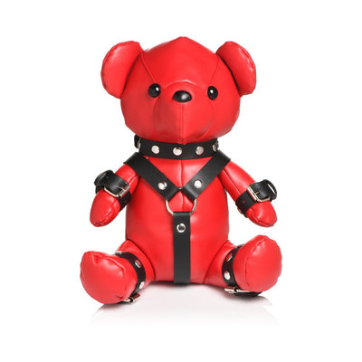 Red vegan leather teddy bear dressed in black gimp harness and cuffs with silver studs and buckles.
