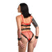 Rear view of a woman wearing a black adjustable vegan leather harness with gold accents and matching wrist restraints over red lingerie.