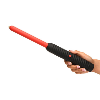 Hand holding Ms Spark Rod Zapping Wand with ribbed black handle and long red shaft against white background.