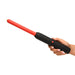 Hand holding Ms Spark Rod Zapping Wand with ribbed black handle and long red shaft against white background.