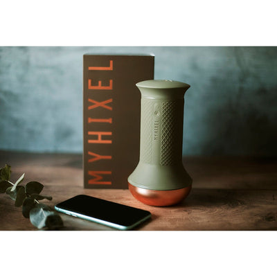 MYHIXEL TR device in olive green with copper base, packaging box, and smartphone on wooden surface with soft background.