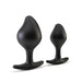 Two black silicone tapered anal plugs with flared bases, shown in large and small sizes on a white background.