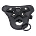 Black adjustable strap-on harness with metal ring and removable silicone ring accessory.