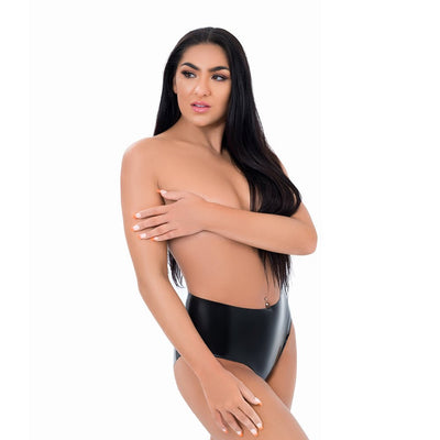 Woman wearing black high-waisted latex crotchless panties posing against white background.