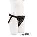 Black adjustable strap-on harness displayed on a white mannequin with two interchangeable O-rings beside it.
