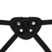 Close-up of black adjustable strap-on harness with metal snaps and O-ring attachment point.
