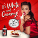 Retro woman in red dress tasting creamy white lubricant with bottle and cherry pie on table against red background