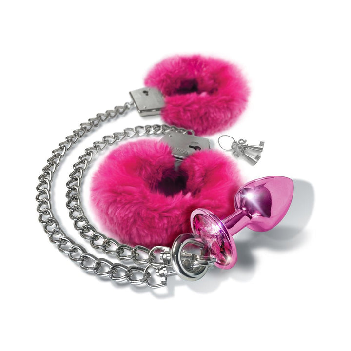 Medium-sized pink metal butt plug with matching pink furry handcuffs and silver chain with keys on white background.
