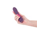 Hand holding a sleek, light purple silicone vibrator with a curved tip and rose gold accent on a white background.