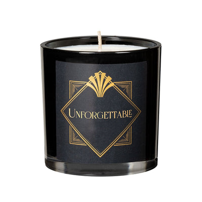 Black glass candle with gold "Unforgettable" label and white wax inside, 6.5oz size.