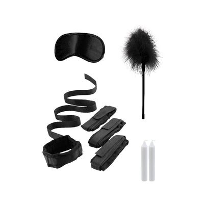 Black and white bed bindings restraint kit with adjustable cuffs, satin blindfold, feather tickler, and two white candles.