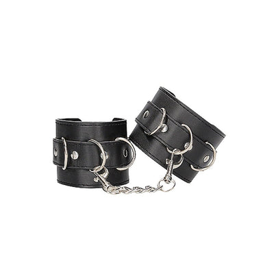 Black and white bonded leather wrist or ankle cuffs with adjustable straps and metal chain connectors.