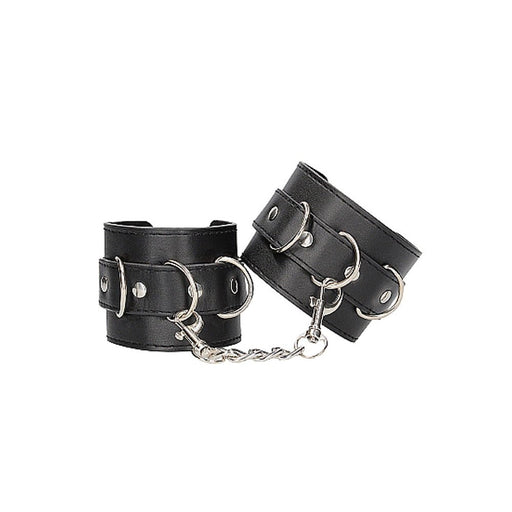 Black and white bonded leather wrist or ankle cuffs with adjustable straps and metal chain connectors.