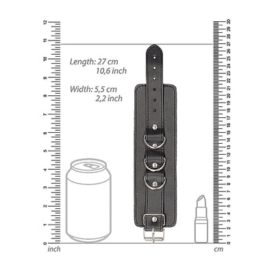 Black and white bonded leather wrist or ankle cuff with adjustable straps shown with size measurements and comparison to a soda can and lipstick.
