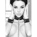 Black and white adjustable Velcro collar and wrist cuffs connected by a metal chain on a model.