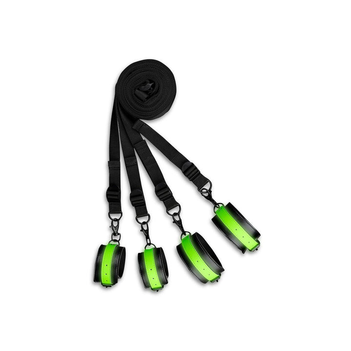 Ouch! Glow Bed Bindings Restraint Kit with black straps and green glow-in-the-dark cuffs for wrists and ankles.