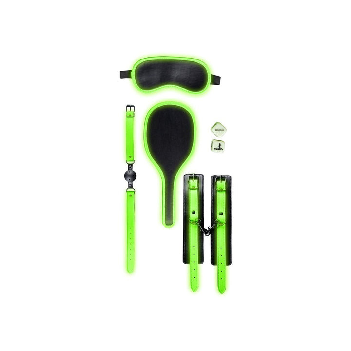 Glow in the dark green and black bondage kit including wrist cuffs, ball gag, paddle, eye mask, and dice on white background.