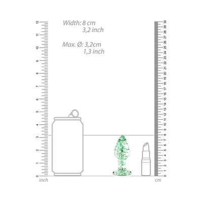 Clear glass butt plug with green glow-in-the-dark speckles shown next to size comparison of soda can and lipstick with rulers.