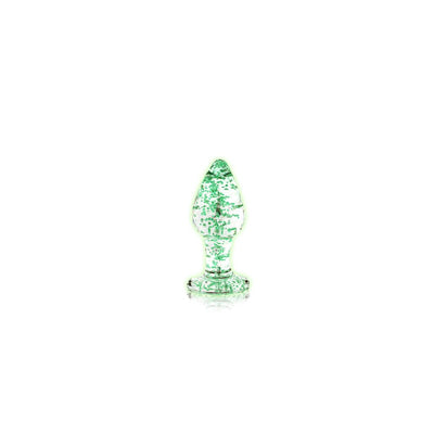Clear glass butt plug with green glow-in-the-dark speckles and a flared base on a white background.
