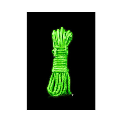 Coiled bright green glow-in-the-dark rope for bondage play on black background