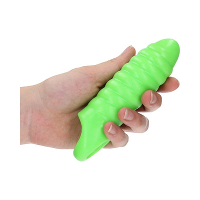 Hand holding a thick, green, ribbed glow-in-the-dark stretchy penis sleeve with a textured swirl design.