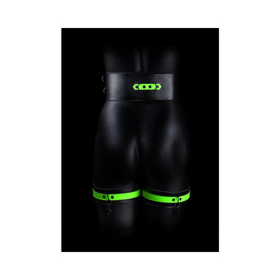 Black mannequin wearing Ouch! Glow in the Dark green-accented thigh cuffs and wide belt against black background.