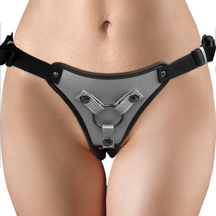 Close-up of a metallic gray adjustable strap-on harness with black straps worn on hips.