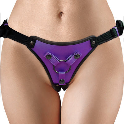 Close-up of a purple metallic adjustable strap-on harness with black straps and metal rings worn on hips.