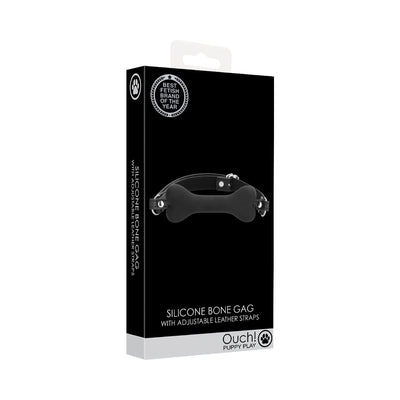 Black silicone bone-shaped gag with adjustable leather straps in sleek black packaging from Ouch! Puppy Play collection.
