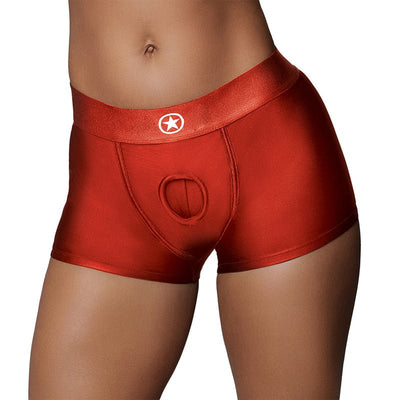 Close-up of red vibrating strap-on boxer shorts with a central O-ring opening and elastic waistband on a model.