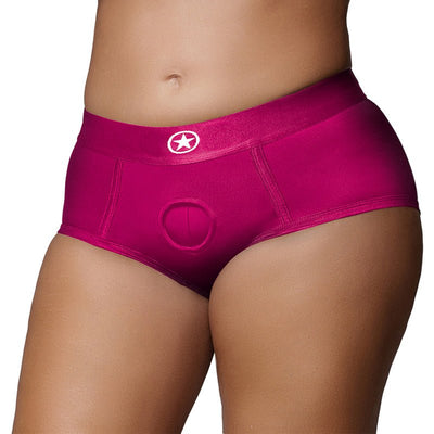 Close-up of mid-rise pink strap-on brief with O-ring system on model, designed for comfort and versatile fit.