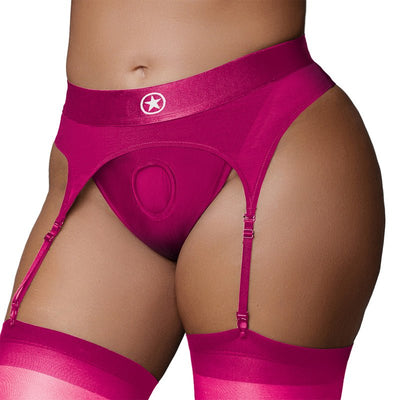 Close-up of pink vibrating strap-on thong with adjustable garters worn with matching thigh-high stockings.