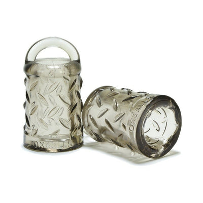 Pair of translucent smoke-colored nipple pullers with textured grip and loop handles by Oxballs.