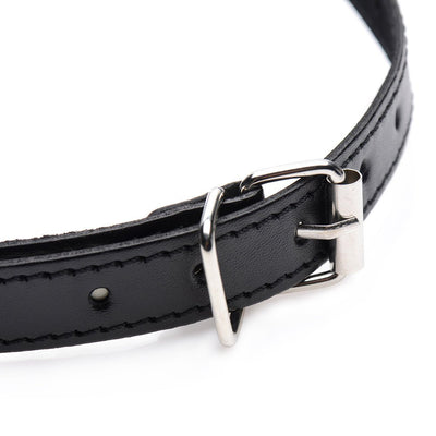 Close-up of black padded bit gag strap with silver buckle and stitching detail on white background.