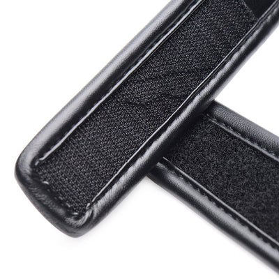 Close-up of black padded blindfold strap with velcro fastening detail in smooth PU leather.