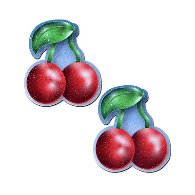 Pair of red cherry-shaped nipple pasties with green leaves and stems on a white background.
