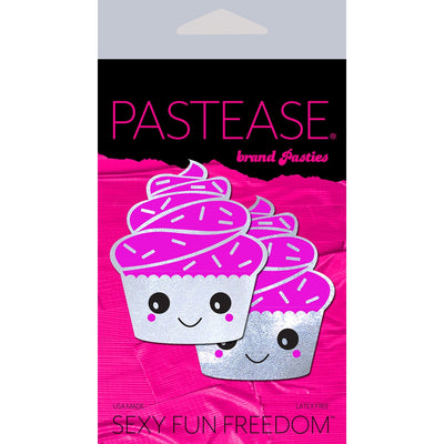Pastease cupcake-shaped nipple pasties with white glittery frosting and smiling faces on bright pink packaging.