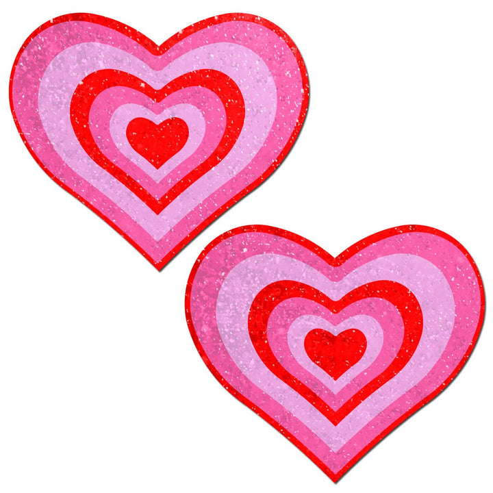 Pair of pink and red glitter velvet heart-shaped nipple pasties with concentric heart design