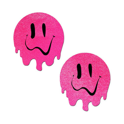 Pair of neon pink circular pasties with melting edges and black dripping smiley face designs.