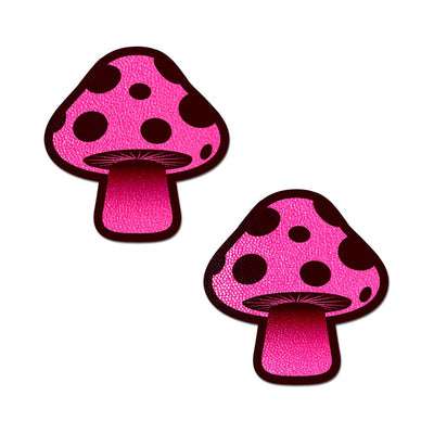 Pair of neon pink mushroom-shaped nipple pasties with black spots and textured finish on a white background.
