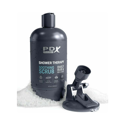 Black PDX Plus Shower Therapy Soothing Scrub bottle with suction cup base surrounded by foam bubbles.