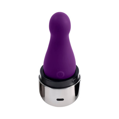 Compact purple silicone vibrator with rounded tip, shown in a sleek silver USB charging base.