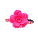 Pink silicone flower-shaped ball gag with adjustable black strap and gold-tone studs on white background.